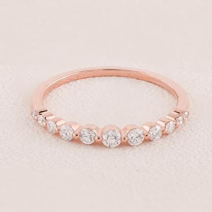 Rose gold ring with diamonds on a light pink background