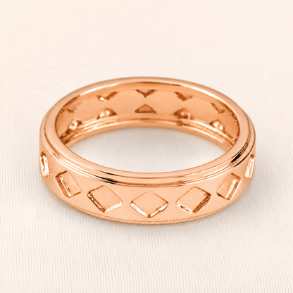 A rose gold band ring with a textured geometric pattern of raised and recessed diamond shapes, shown on a light beige textured background.
