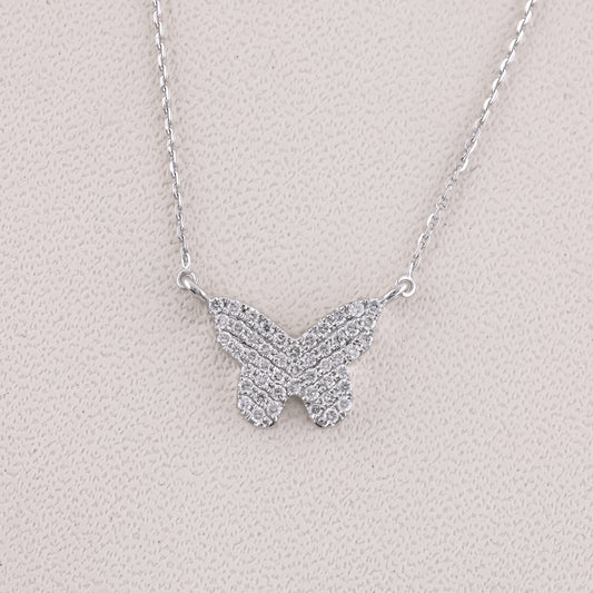 Butterfly-shaped necklace with sparkling stones on a light gray background
