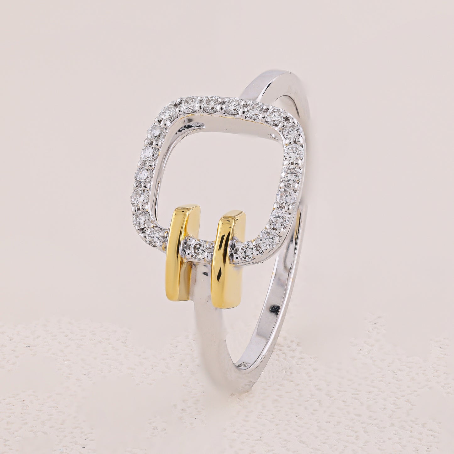 Silver and gold ring with diamond accents on a light beige background