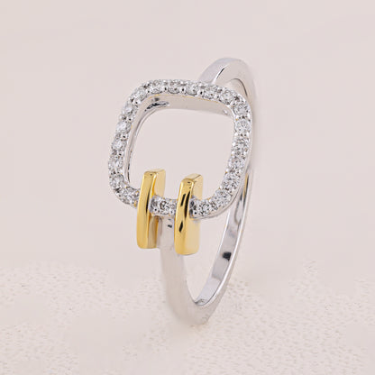 Silver and gold ring with diamond accents on a light beige background
