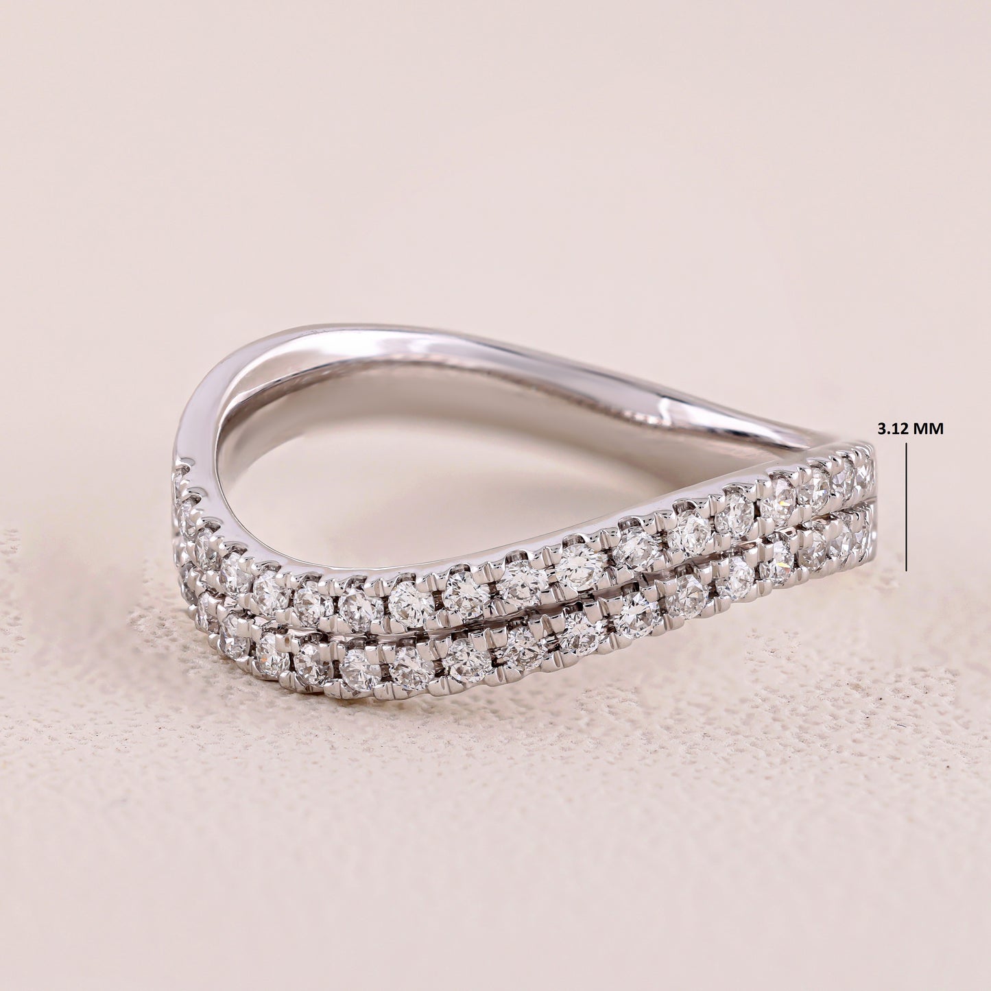 Silver ring with diamond accents on a beige background