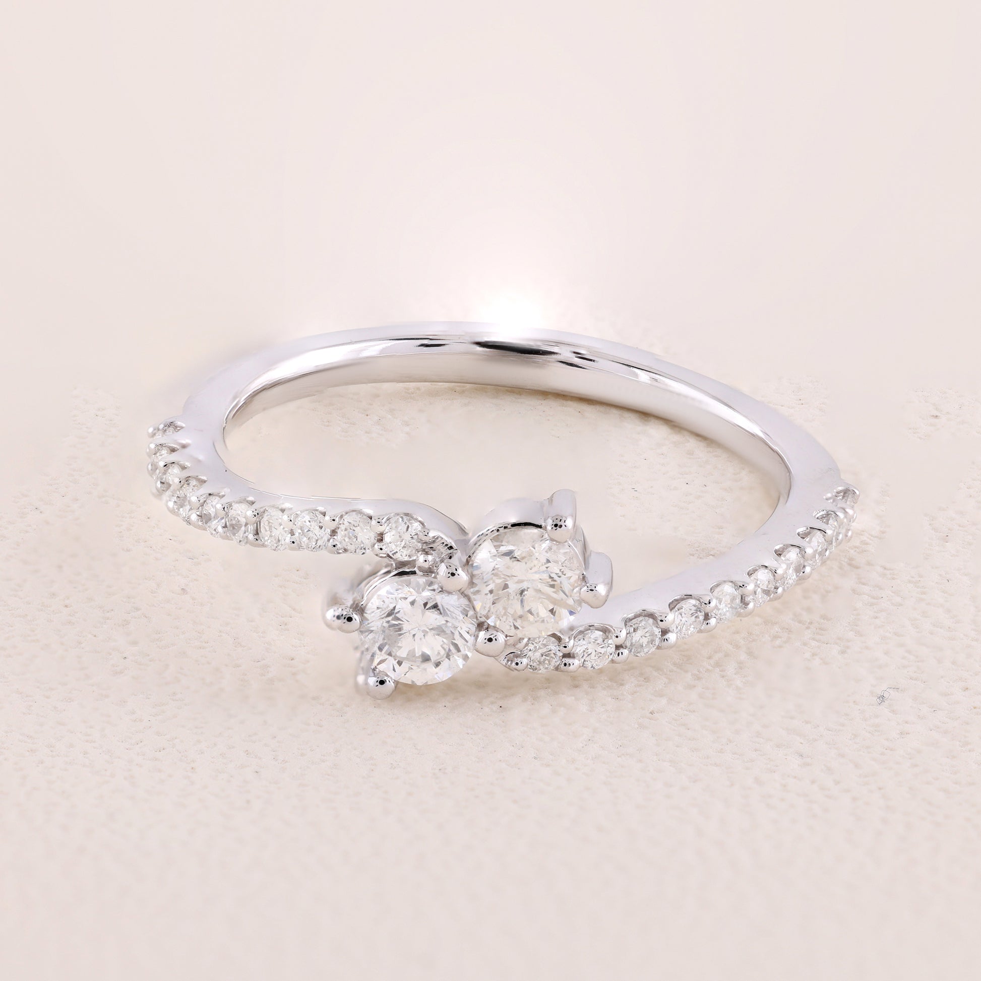 Silver ring with a diamond on a beige background