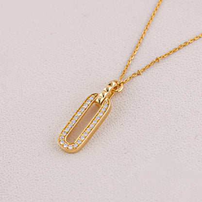 Gold necklace with a pendant on a light gray background