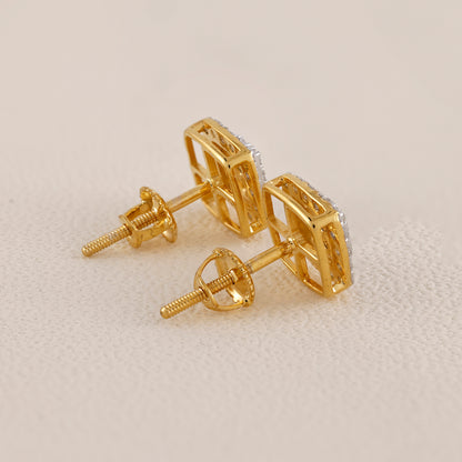 Gold earrings on a beige background