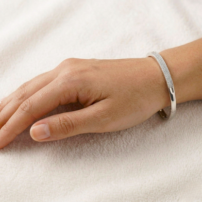 Silver bracelet on a person's wrist against a light background