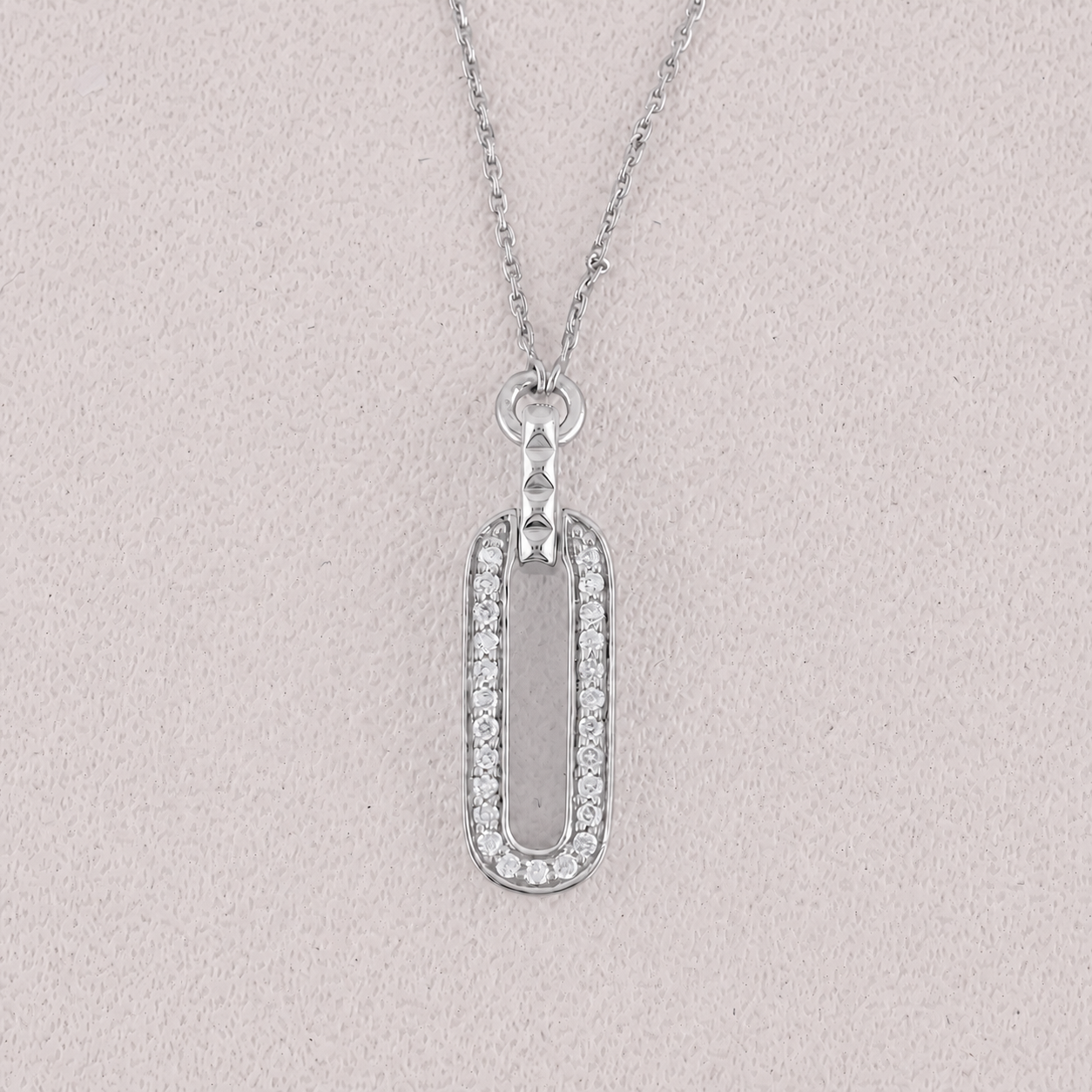 Silver necklace with a rectangular pendant on a light gray background