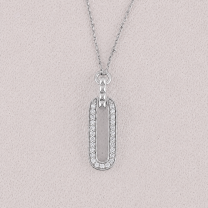 Silver necklace with a rectangular pendant on a light gray background