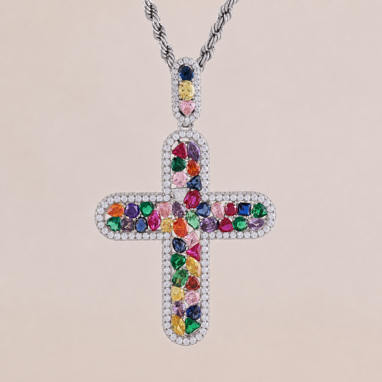 Cross-shaped pendant with colorful gemstones on a beige background