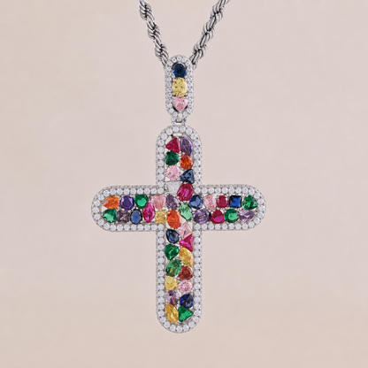 Cross-shaped pendant with colorful gemstones on a beige background