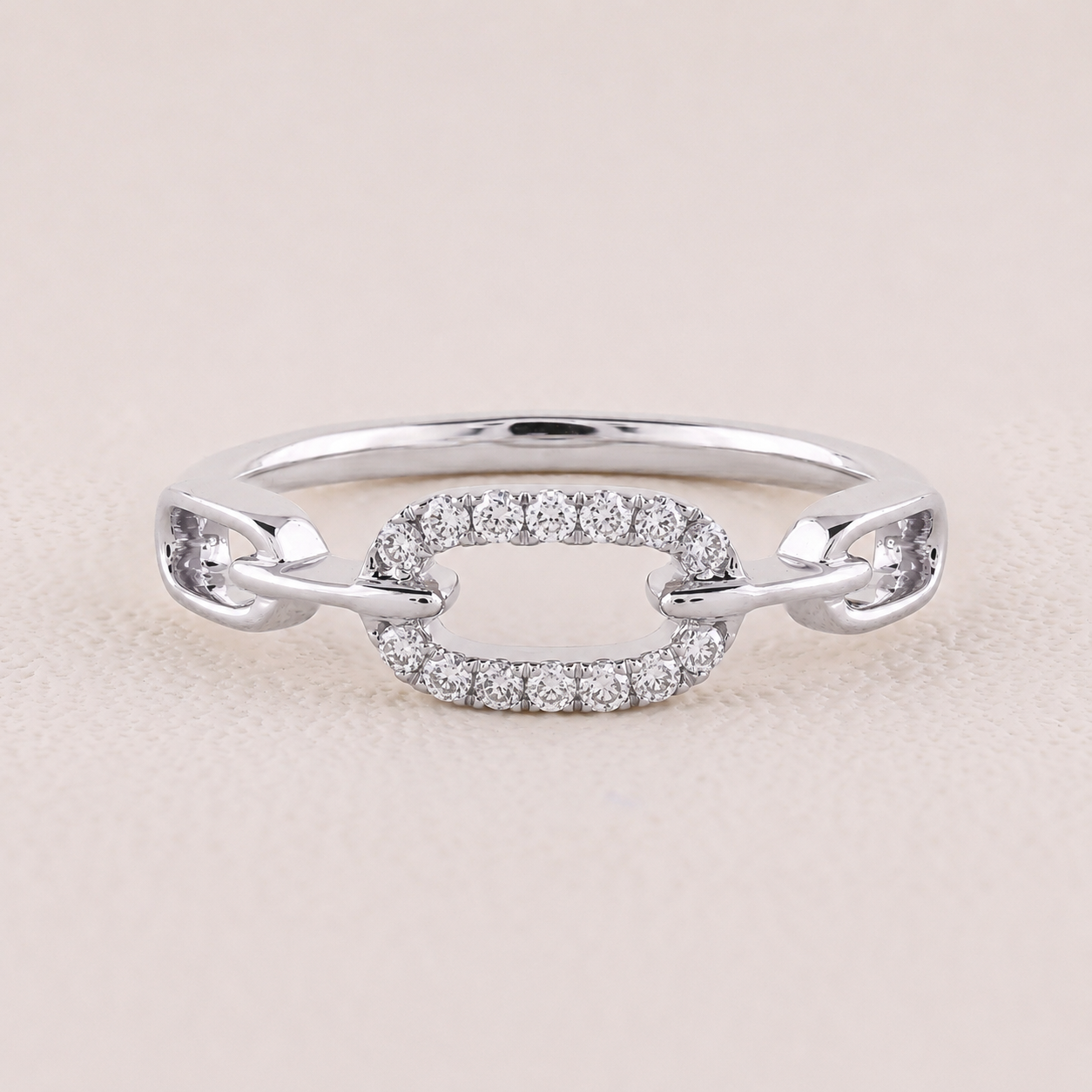 Silver ring with diamond accents on a light beige background