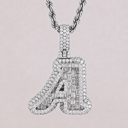 Diamond-studded letter 'A' pendant on a chain against a light pink background