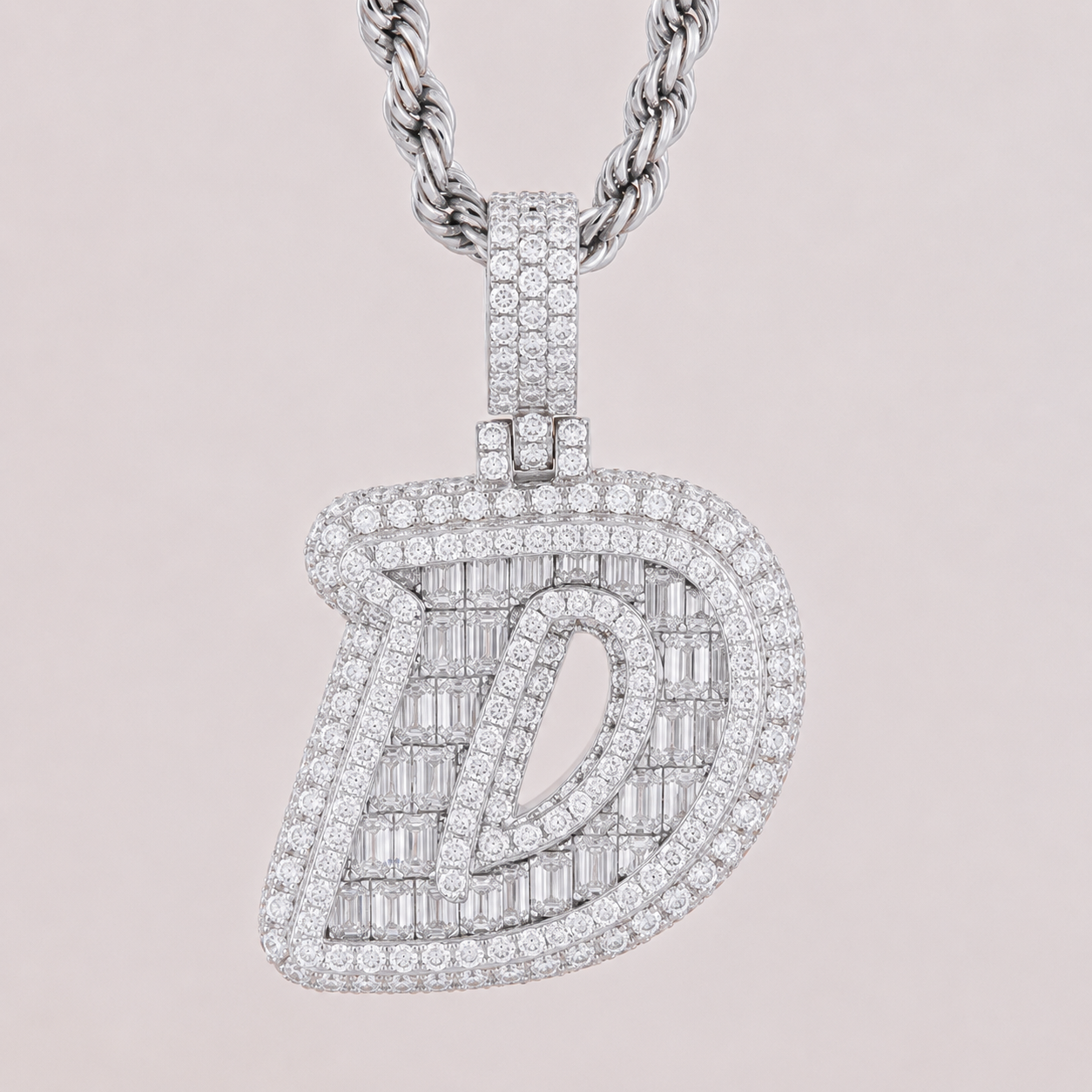 Diamond-encrusted pendant on a chain against a light pink background