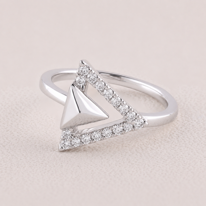 Silver ring with a triangle design on a light pink background