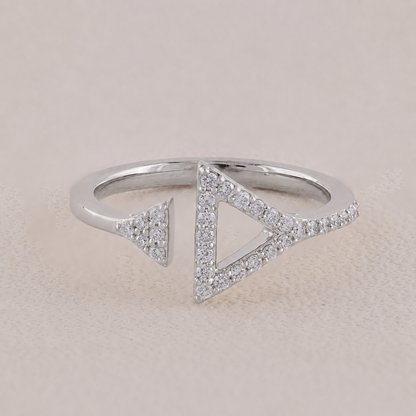 Silver ring with triangle designs on a beige background