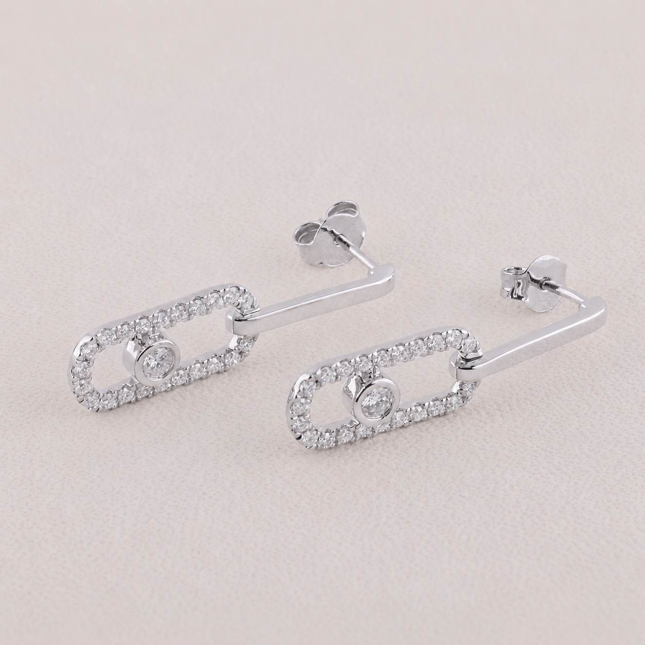 Silver earrings with clear gemstones on a light gray background