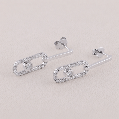 Silver earrings with clear gemstones on a light gray background