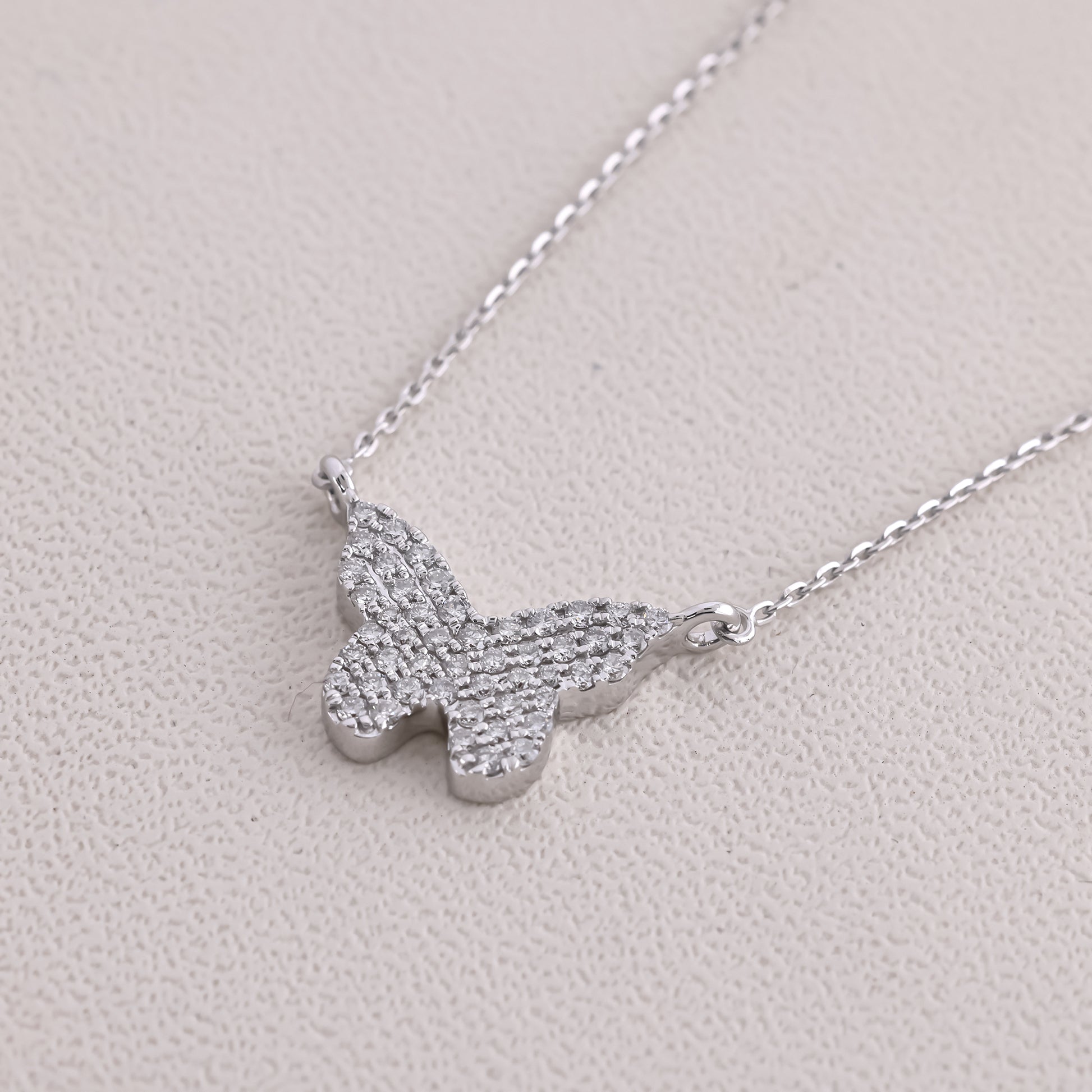 Silver butterfly necklace on a light gray background
