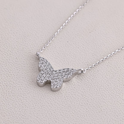 Silver butterfly necklace on a light gray background