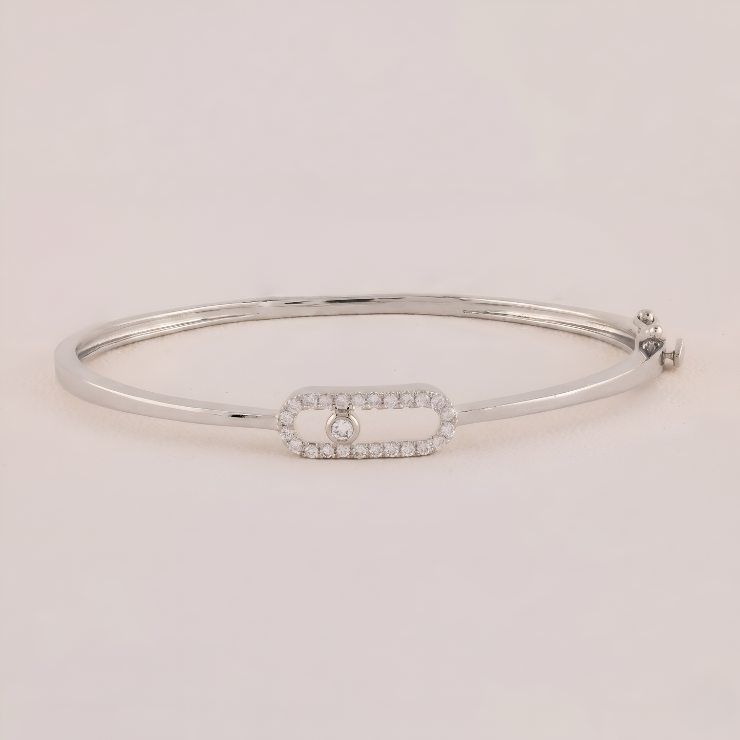 Silver bracelet with a small diamond on a light pink background