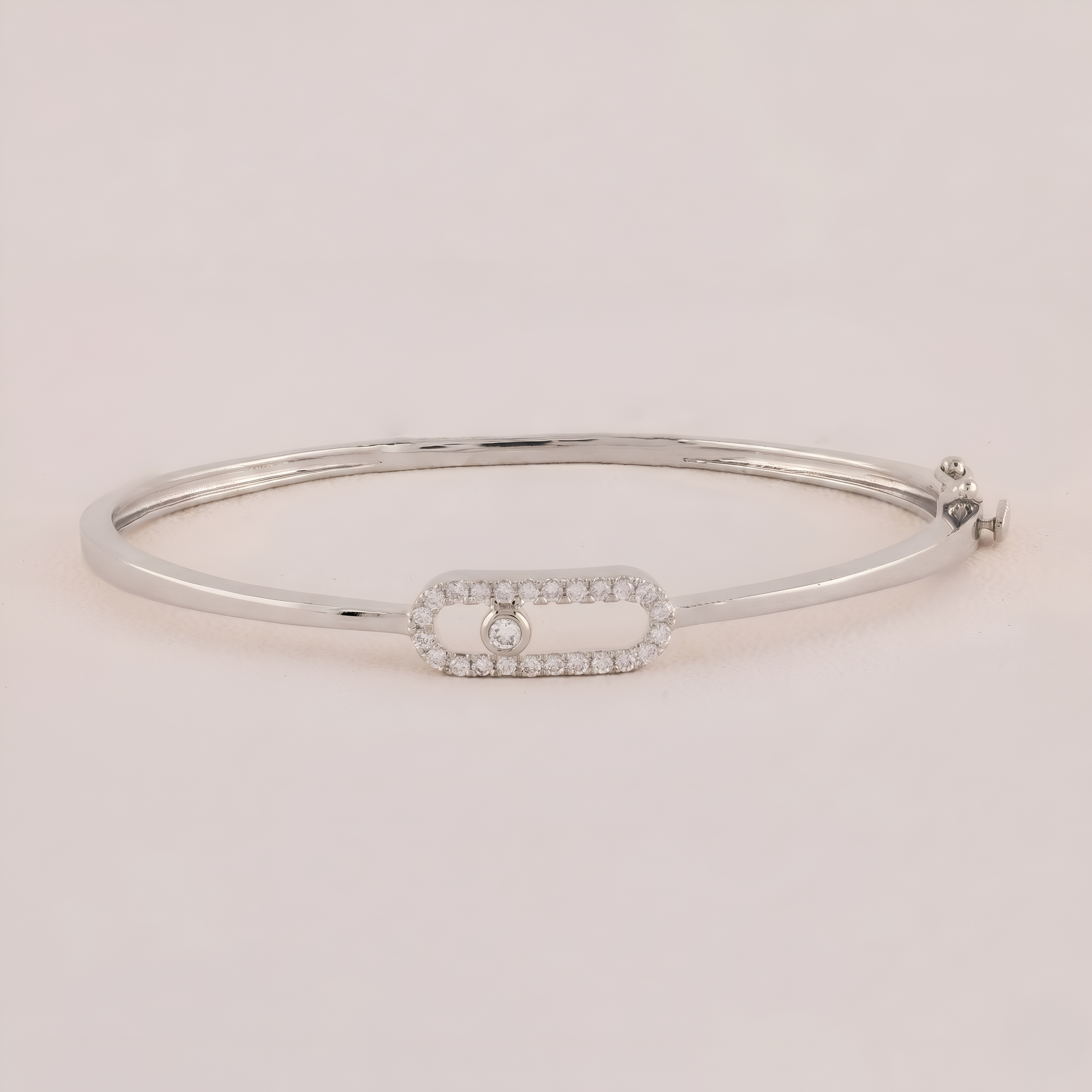Silver bracelet with a small diamond on a light pink background