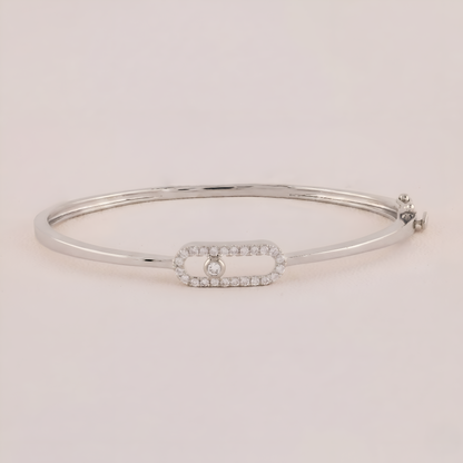 Silver bracelet with a small diamond on a light pink background