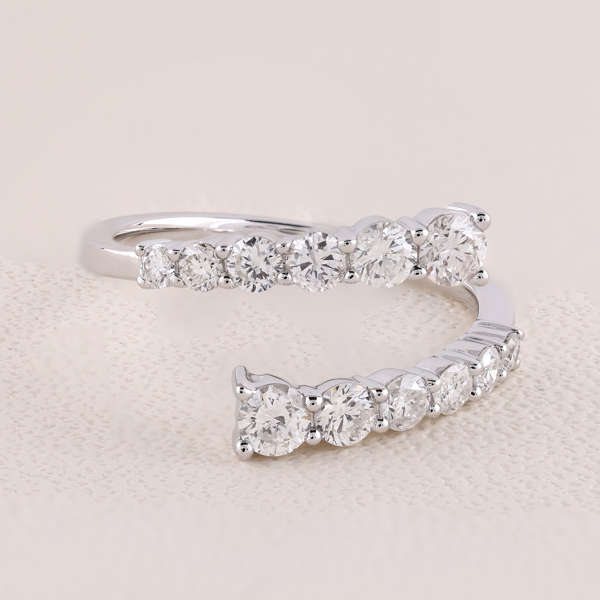 Silver ring with diamond stones on a beige background
