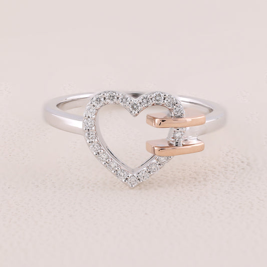 Heart-shaped ring with diamond accents on a light pink background