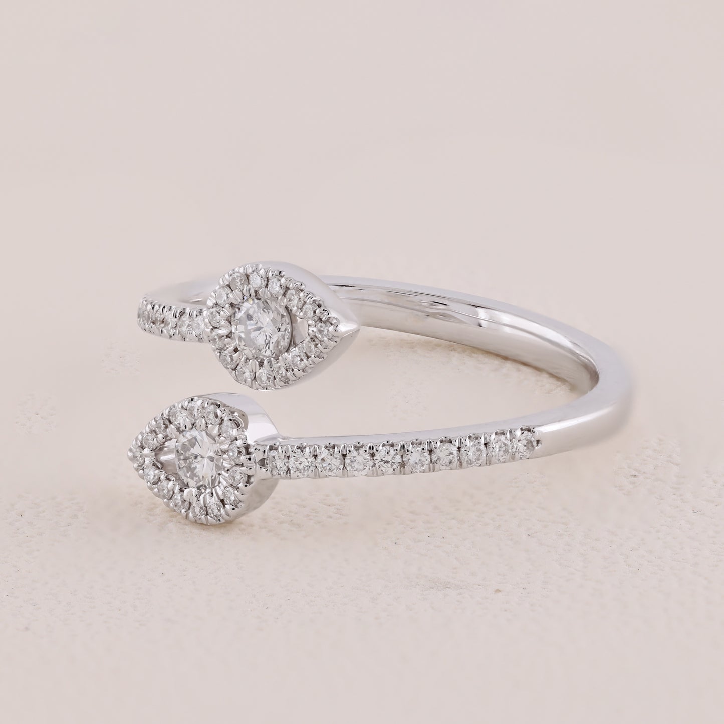 Silver ring with diamond accents on a light beige background