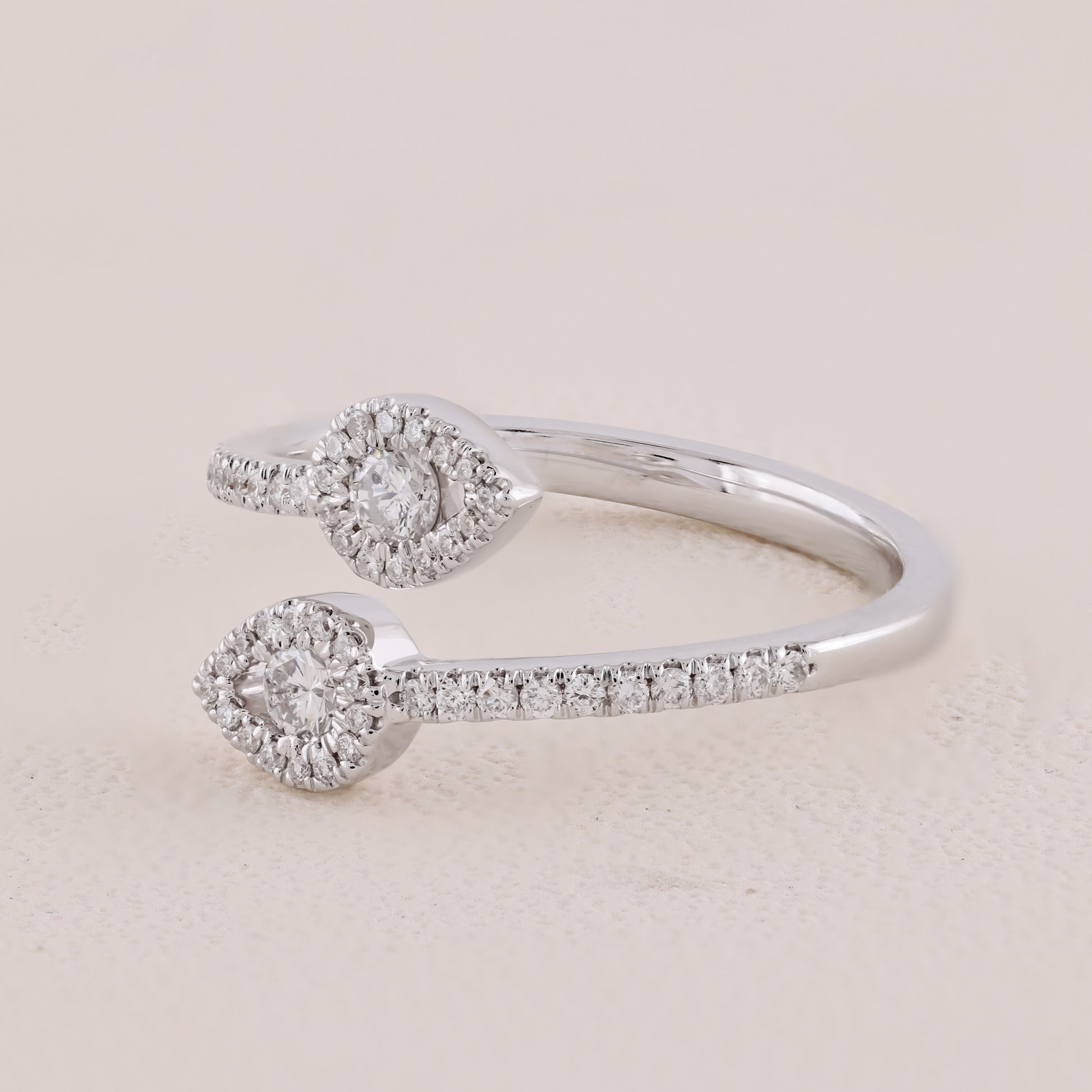 Silver ring with diamond accents on a light beige background