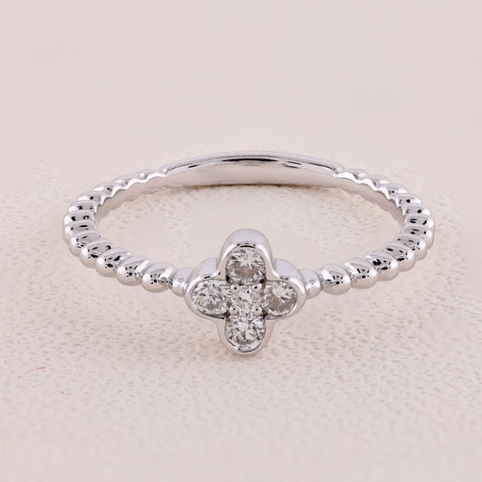 Silver ring with a clover-shaped diamond on a beige background