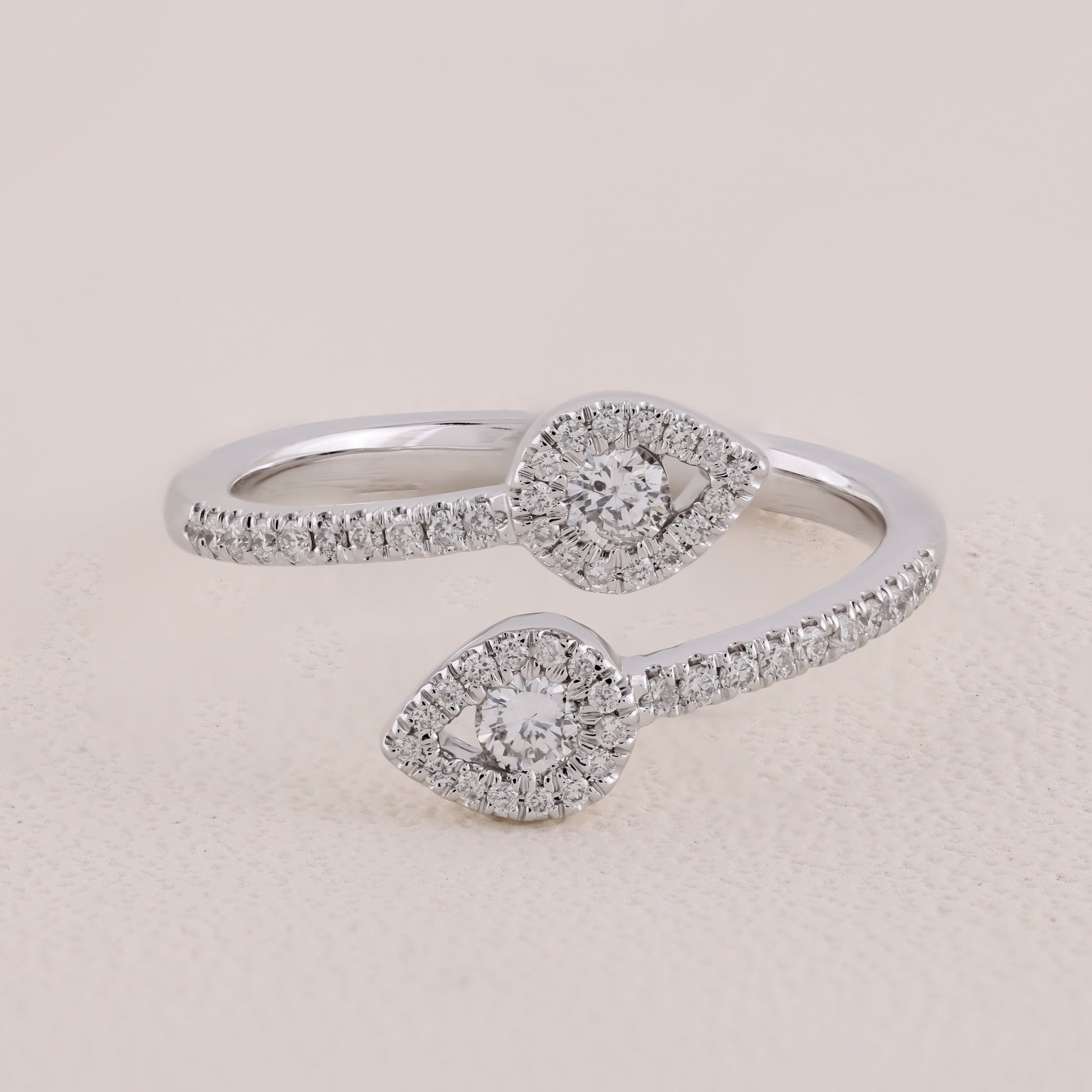 Silver ring with diamond accents on a beige background