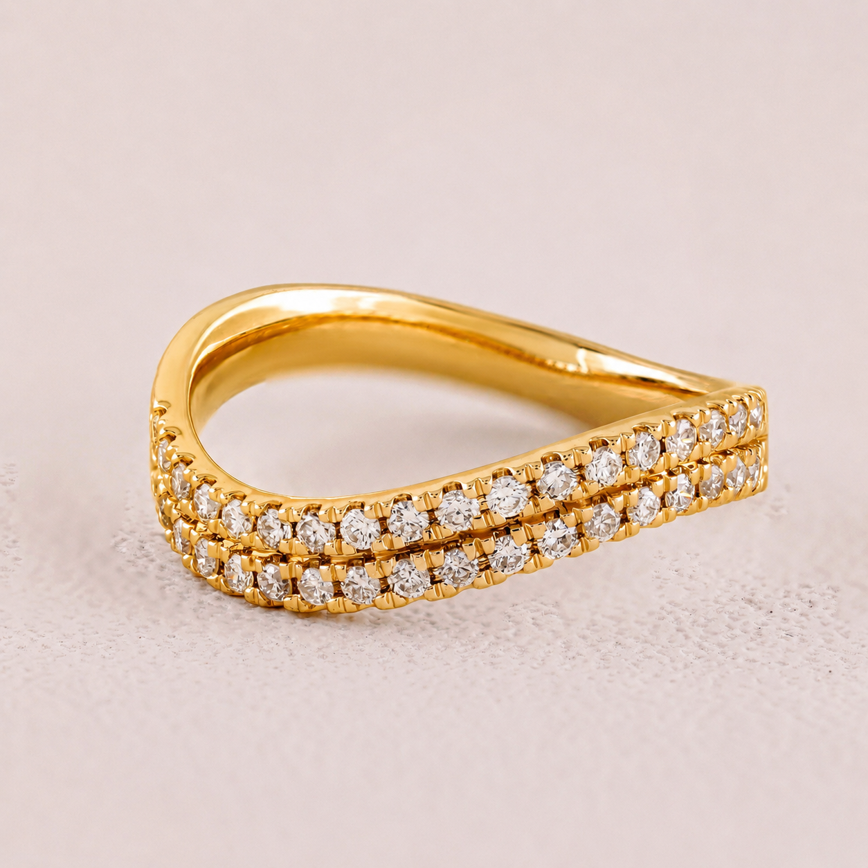 Gold ring with diamond accents on a light beige background