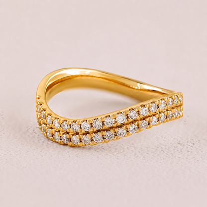 Gold ring with diamond accents on a light beige background