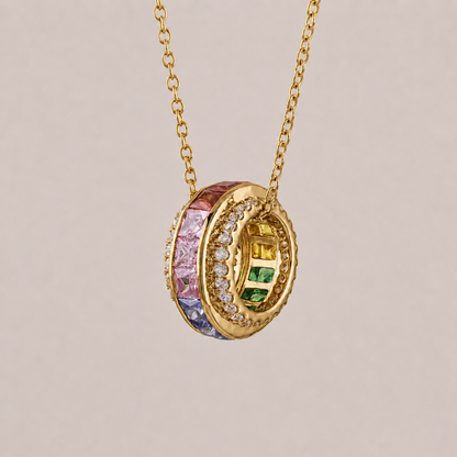 Gold necklace with a colorful pendant on a beige background
