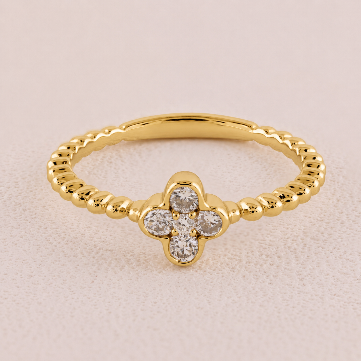 Gold ring with diamond accents on a beige background