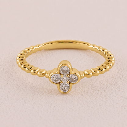 Gold ring with diamond accents on a beige background