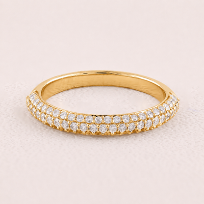 Gold ring with diamonds on a light pink background
