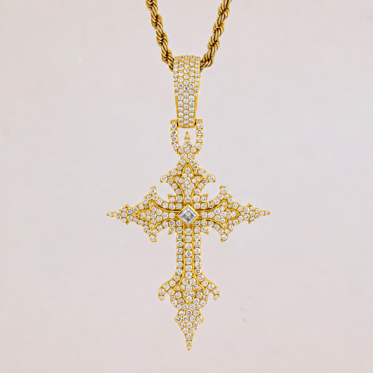 Gold cross pendant necklace with diamonds on a light gray background