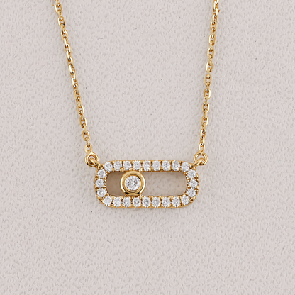 Gold necklace with a pendant on a light gray background