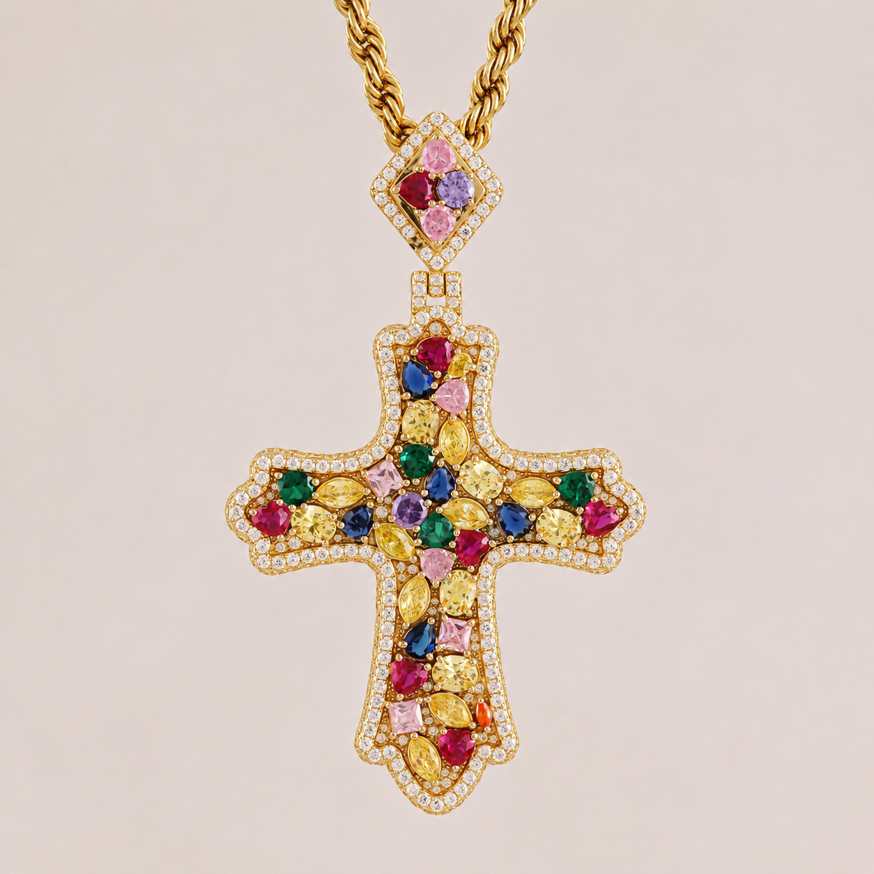 Gold cross pendant with colorful gemstones on a beige background