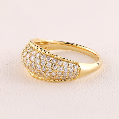 Gold ring with diamond accents on a light pink background