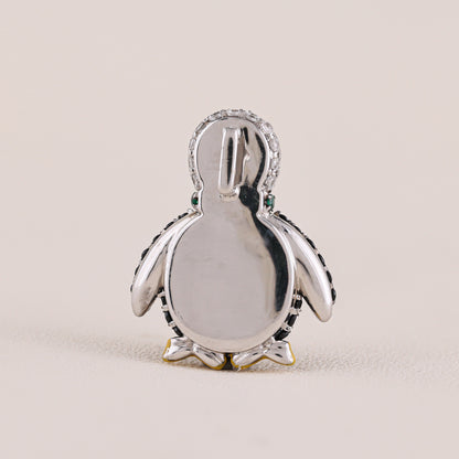Silver penguin pendant on a beige background