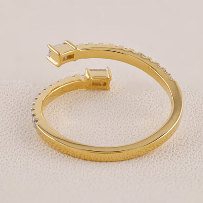Gold bracelet with embedded stones on a textured beige surface