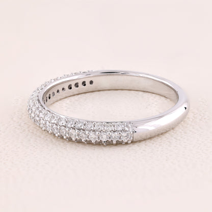 Silver ring with diamond accents on a light pink background