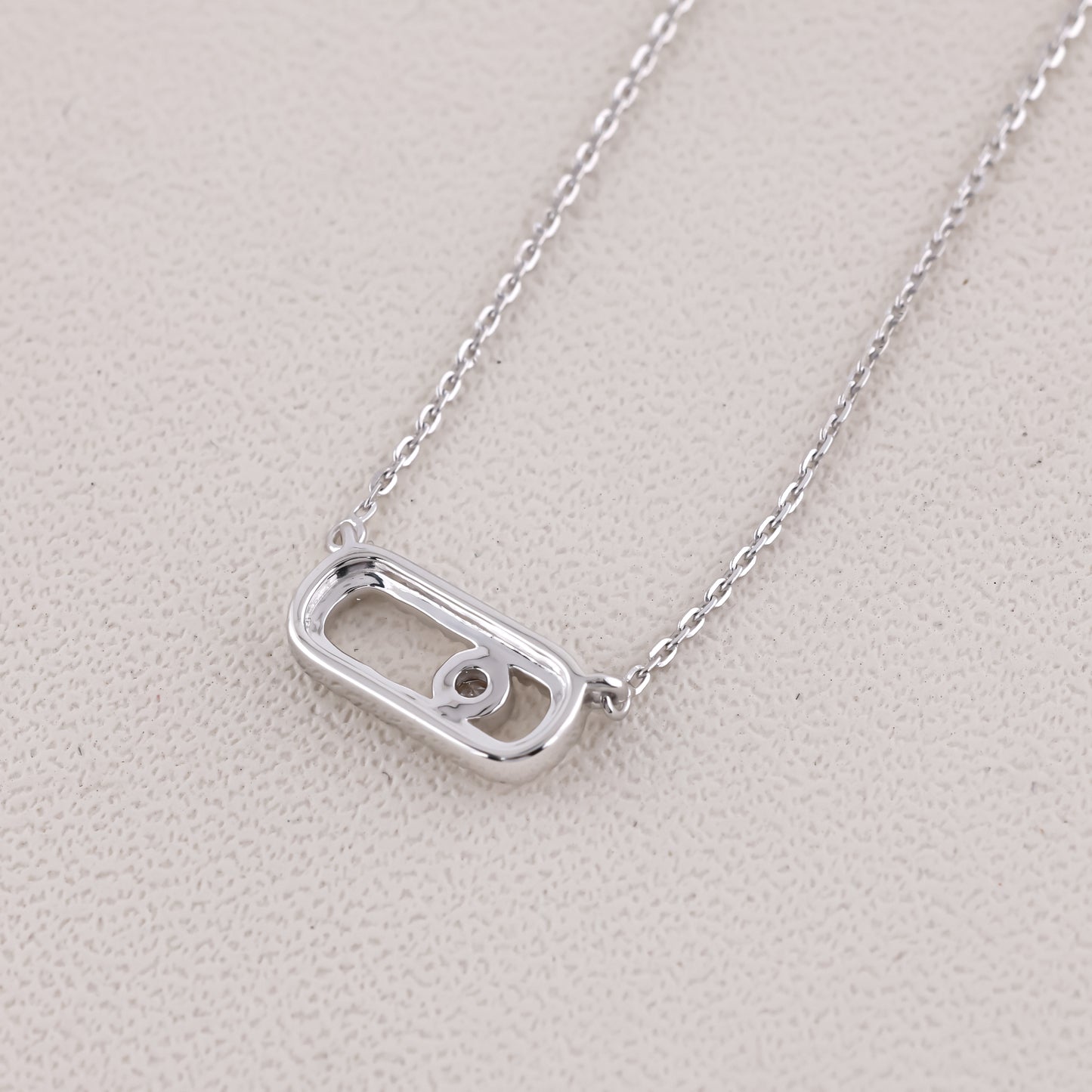 Silver necklace with a unique pendant on a light gray background