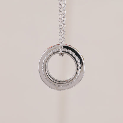Silver circular pendant necklace on a light beige background