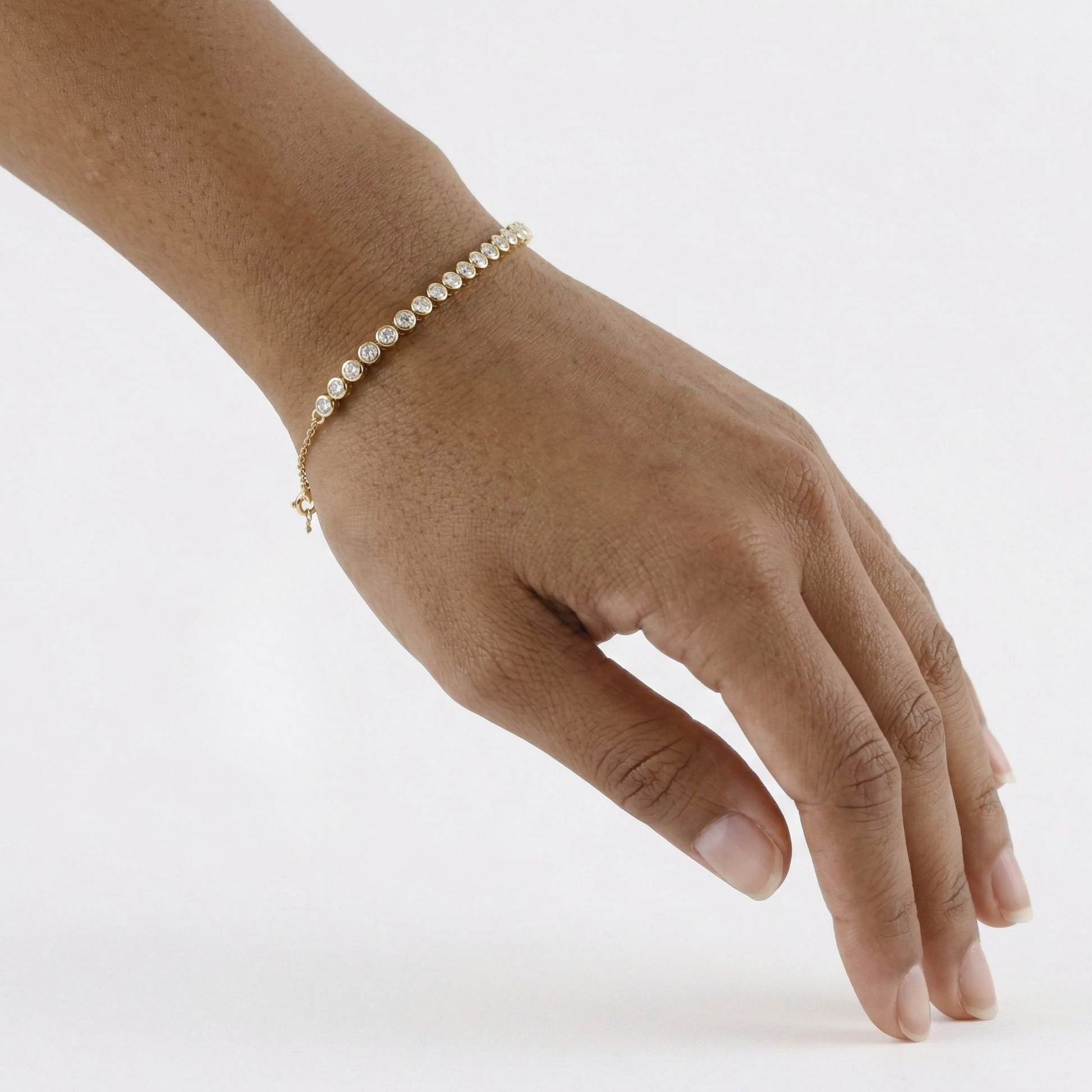 Hand wearing a delicate pearl bracelet on a white background