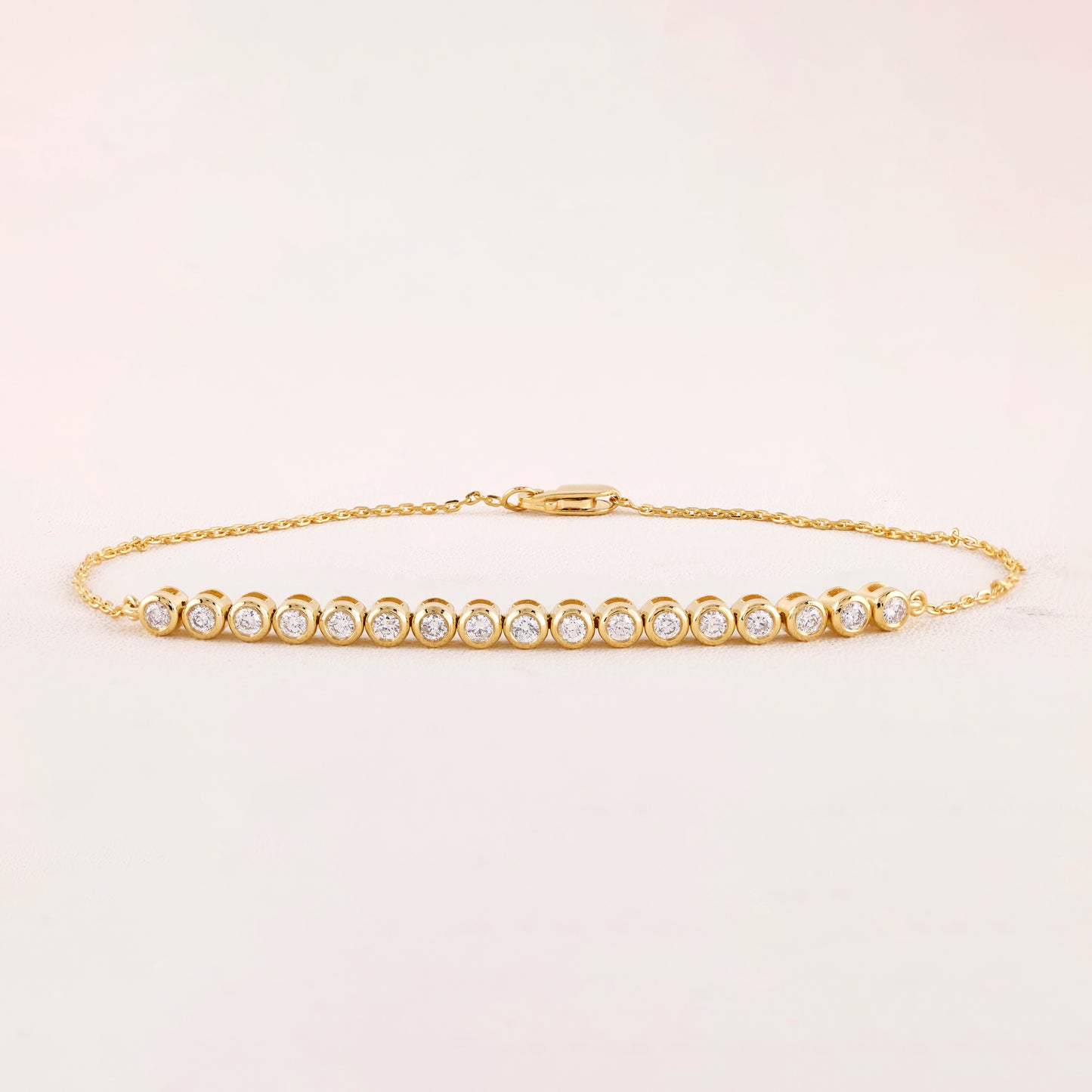 Gold bracelet with diamonds on a light beige background