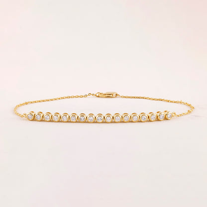 Gold bracelet with diamonds on a light beige background